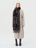 Full body view of a woman in a beige cardigan and black scarf with text