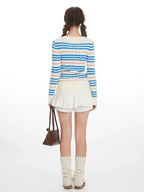 Back view of a woman in a blue and white striped knit sweater.