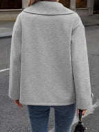 Back view of a woman wearing a grey wool blend pea coat, highlighting its boxy silhouette.
