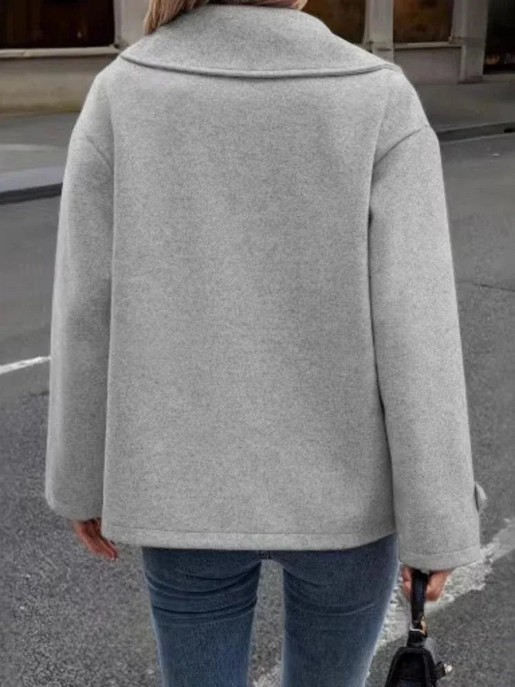 Back view of a woman wearing a grey wool blend pea coat, highlighting its boxy silhouette.