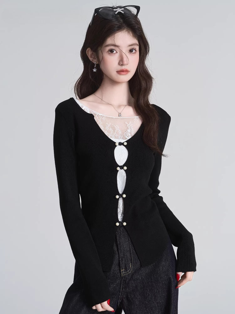 Close-up of a black knit top with lace detail and decorative buttons