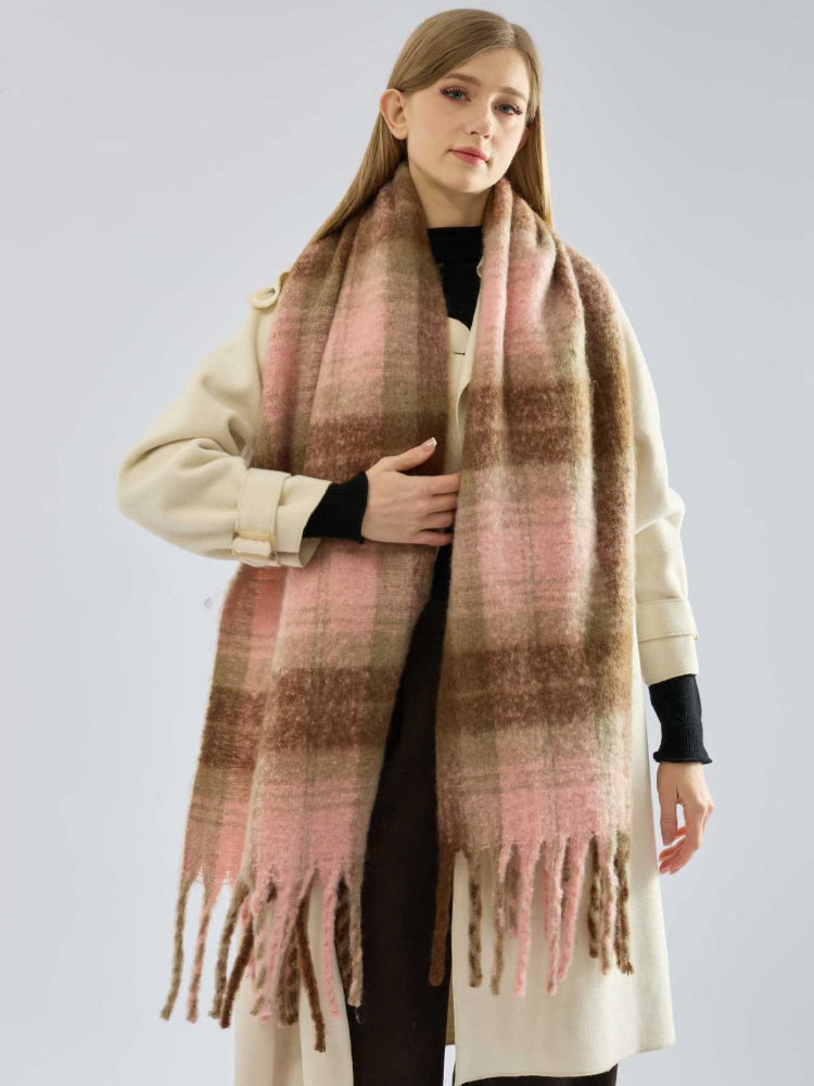 Model showcasing a warm, oversized plaid scarf with frayed edges.