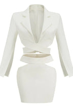 White long-sleeve crop top with wrap-around bodice and cut-outs, paired with a white mini skirt.