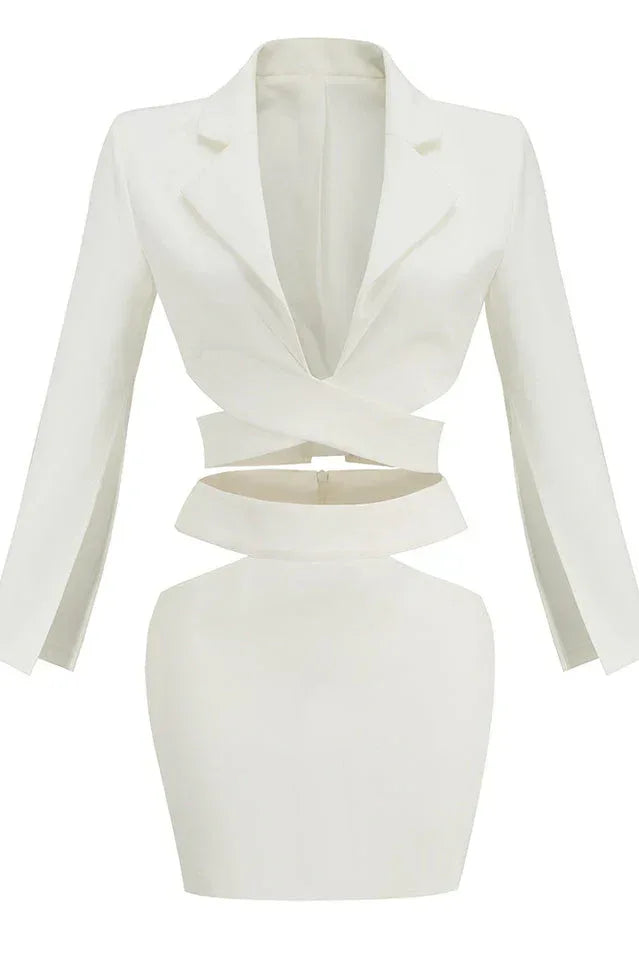 White long-sleeve crop top with wrap-around bodice and cut-outs, paired with a white mini skirt.