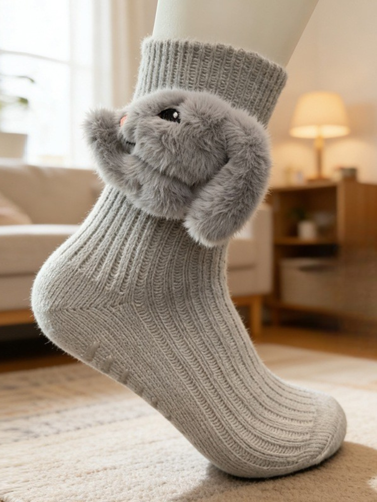 Gray crew socks with a 3D fluffy bunny applique on the ankle, featuring a ribbed texture and non-slip grips on the sole.