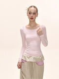 Model wearing a light pink long-sleeve fitted top with a square neckline.