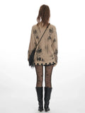 Back view of a tan knit cardigan with abstract black print and distressed hem.