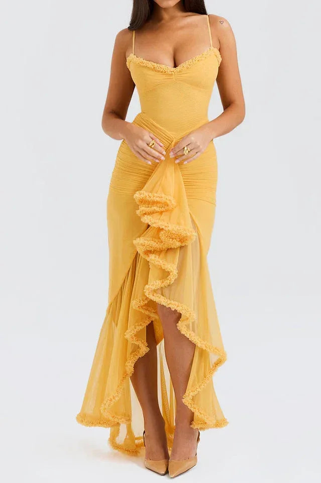 Close-up front view of a woman in a yellow ruched mesh evening dress with spaghetti straps and tiered ruffles.