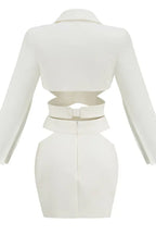 Back view of a white women's two-piece set featuring a crop top with cut-outs and a mini skirt.