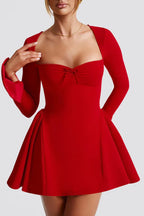 Close-up of a red dress with a sweetheart neckline and pleated A-line skirt