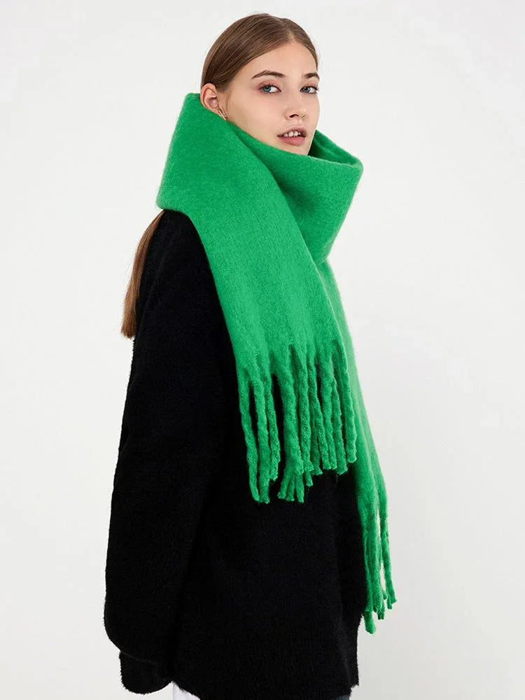 Side profile of a woman wearing a bright green brushed wool blend scarf with fringe trim.