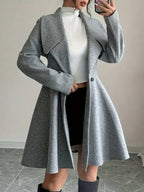 Woman showing off the open front of a grey fit-and-flare wool blend tweed coat.