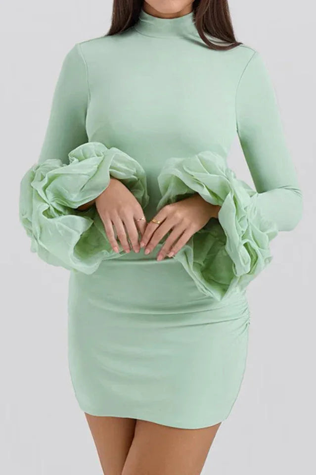 Close-up of mint green bodycon mini dress with ruffled cuffs and ruched detailing