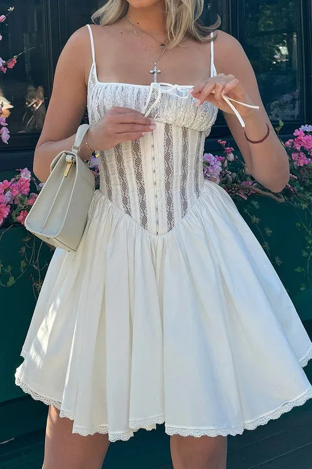 Model wearing a white lace-trimmed corset dress with spaghetti straps and a flared skirt.