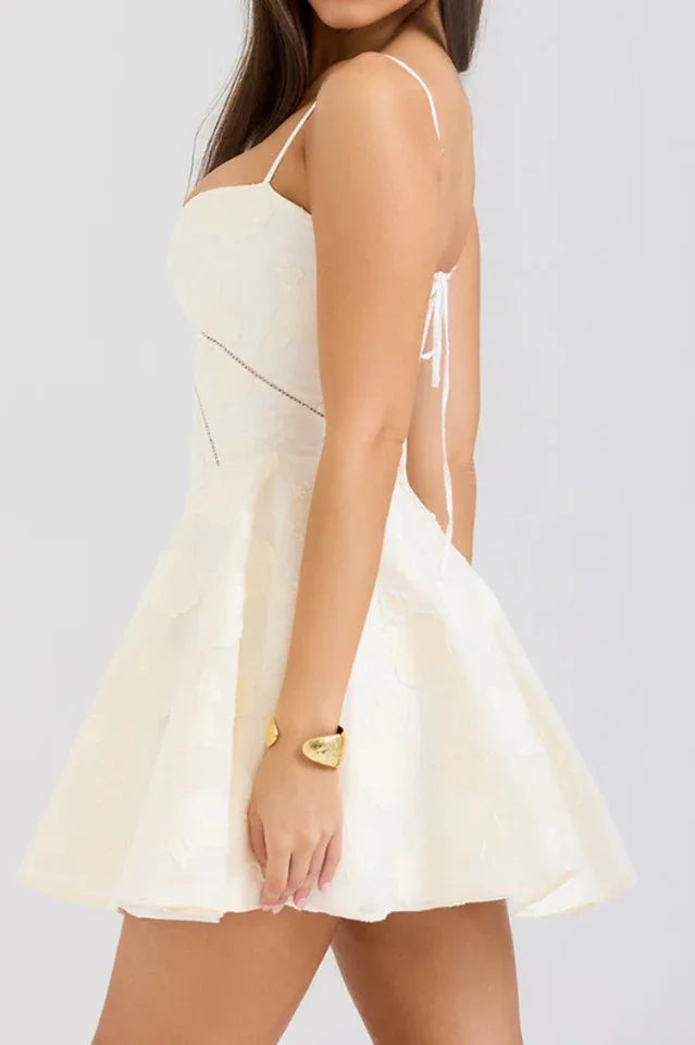 Side view of a woman in a white fit and flare dress with a sweetheart neckline.