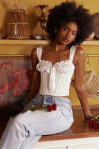 Woman wearing a white satin corset top with light wash jeans