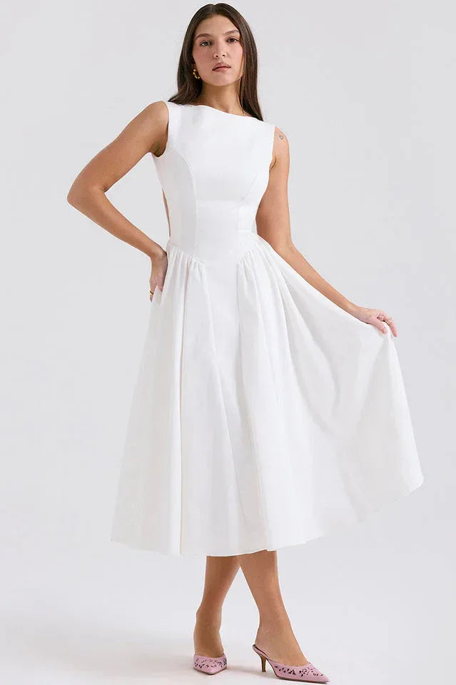 Woman wearing a white sleeveless midi dress with a boat neck and pleated skirt. Main image