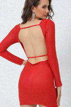 Rear view of a woman in a red rhinestone long-sleeve bodycon mini dress with an open back and thin straps.
