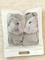 Pair of gray crew socks with 3D fluffy bunny appliques, packaged in a clear zip-lock bag.
