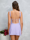 Rear view of a woman in a lavender crepe sheath mini dress showing the criss-cross back detail