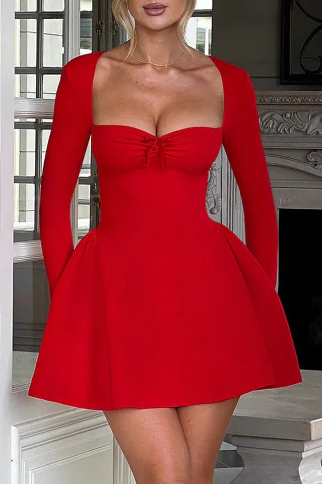 Woman wearing a red fit and flare dress with a sweetheart neckline and long sleeves
