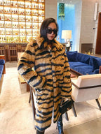 Woman wearing a faux fur tiger stripe coat inside a lounge.