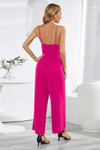 Back view of a woman in a fuchsia wide leg jumpsuit with spaghetti straps.