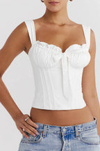 Close-up of a white satin corset top with ruching and a bow