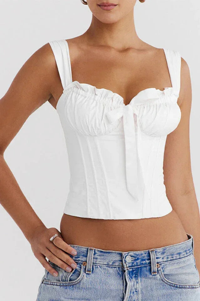 Close-up of a white satin corset top with ruching and a bow