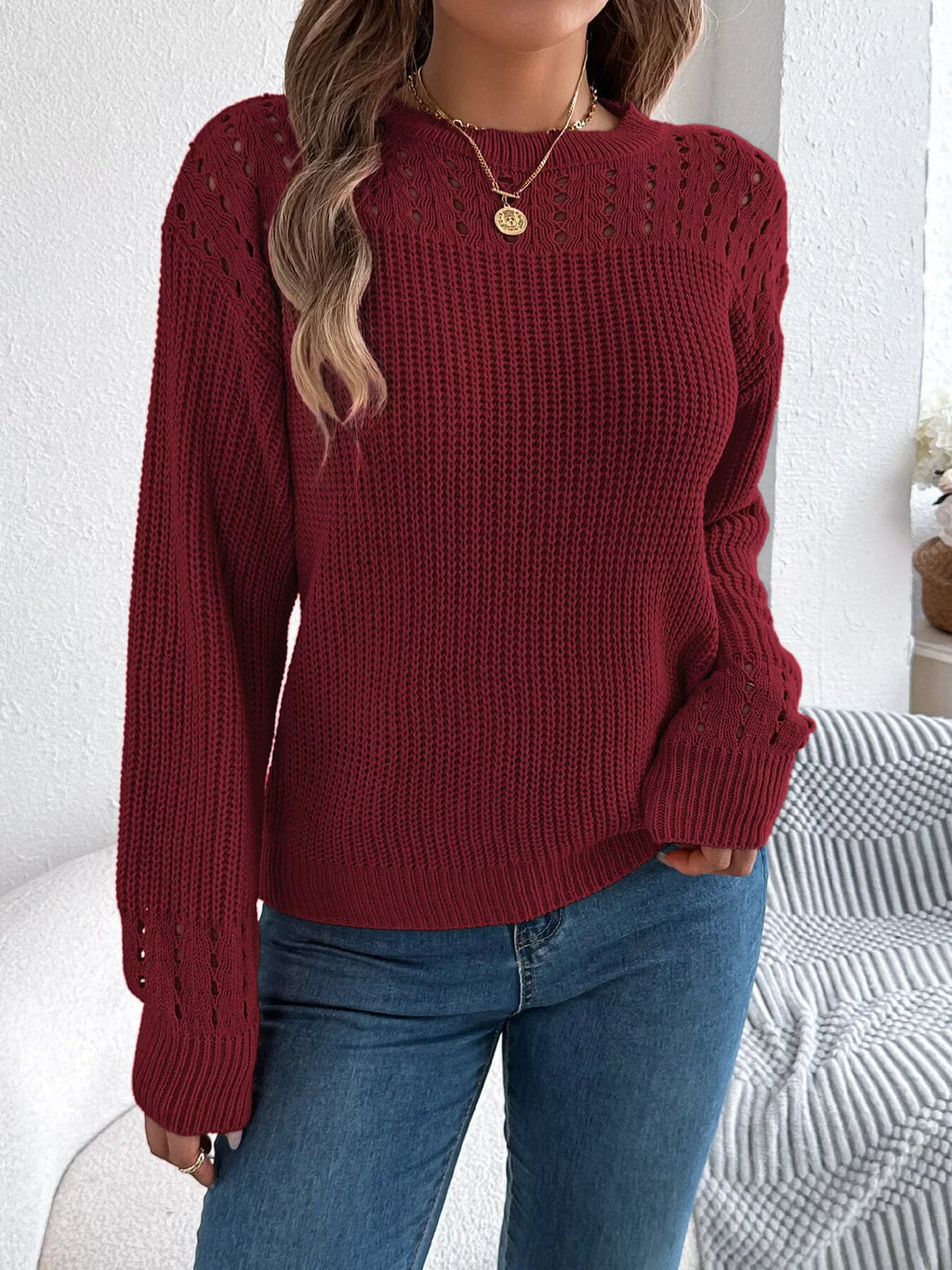 Front view of a woman in a maroon knit sweater with crew neck and long sleeves.