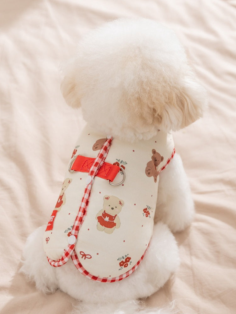 Back view of a cream-colored dog vest with teddy bear and floral print, showing red gingham trim and D-rings.