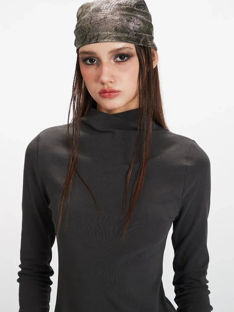 Model with a bandana and dark grey mock neck long sleeve top.
