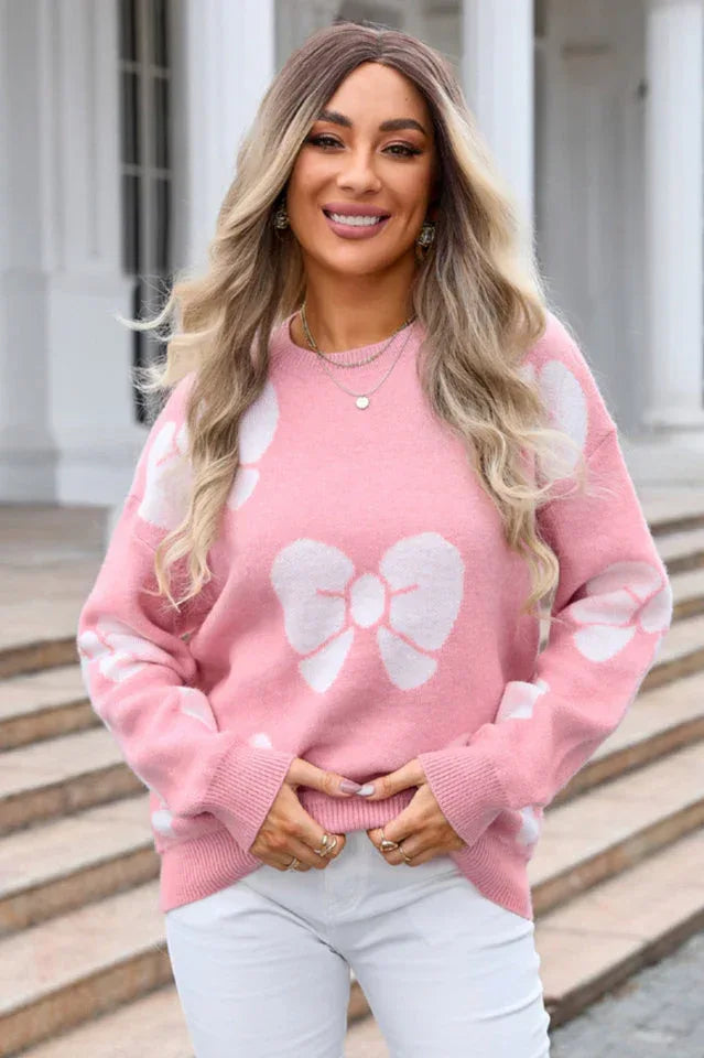 woman wearing a pink knit sweater with white bow print and crew neck