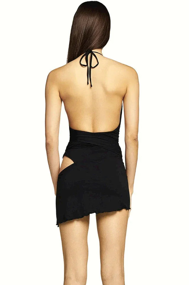 Back view of a woman in a black halter neck mini dress with side cutouts.