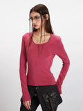 Model posing in a rose red long sleeve scoop neck top