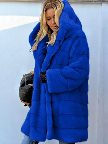 Woman wearing a vibrant blue faux fur hooded coat with horizontal stripe detailing.