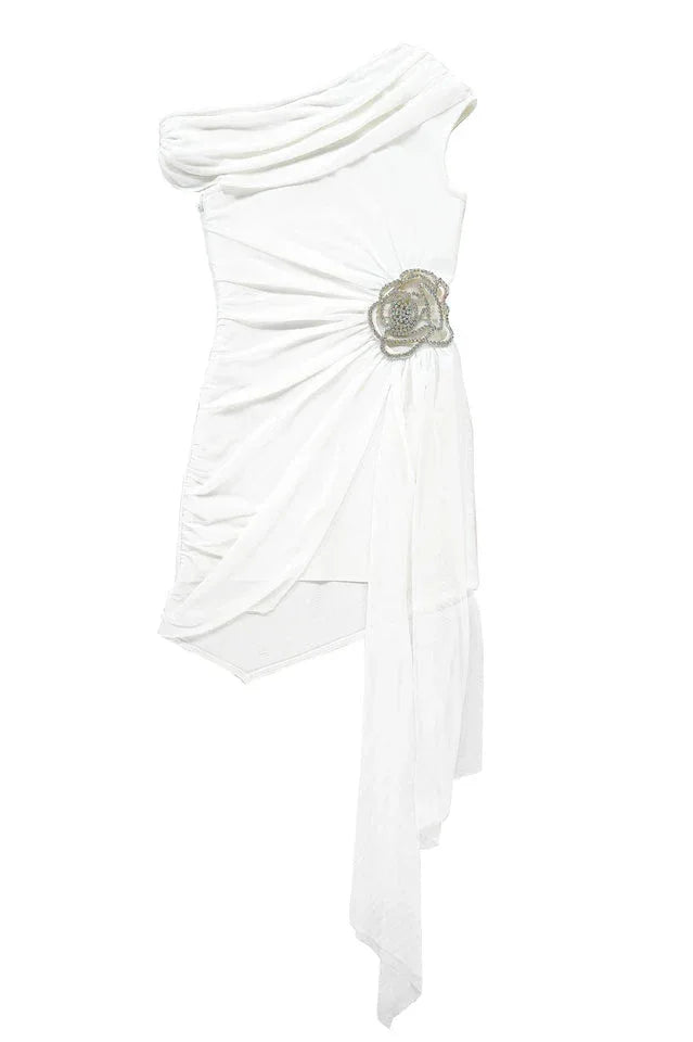 White one-shoulder asymmetrical mini dress with ruched detailing, draped chiffon overlay, and a floral embellishment, shown flat.