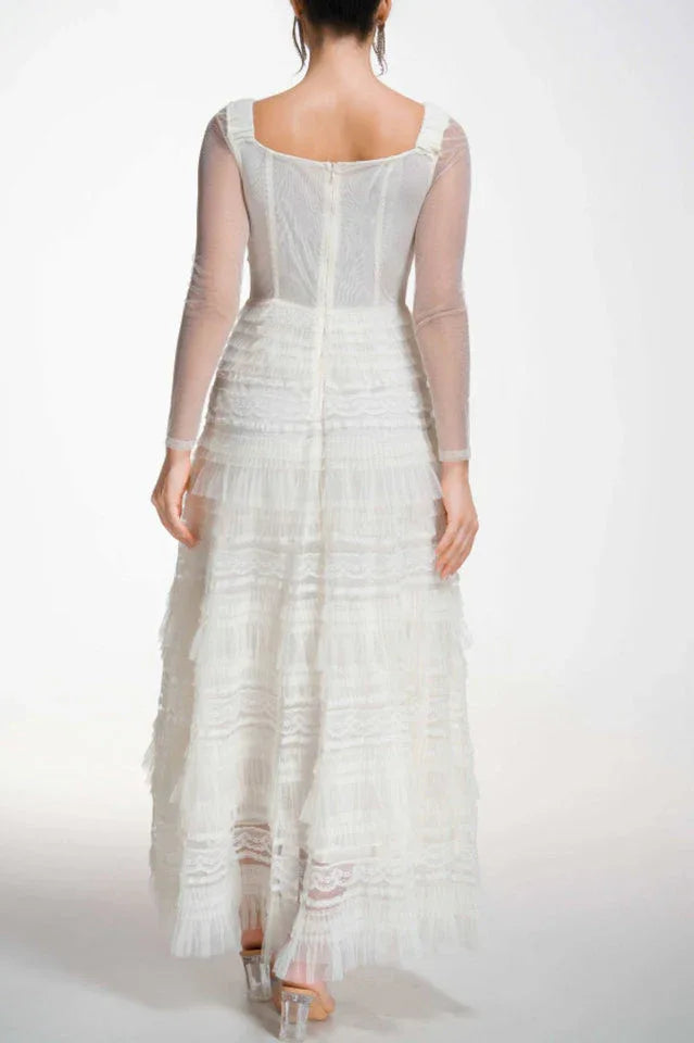 Back view of a white formal gown with a zipper closure and sheer sleeves
