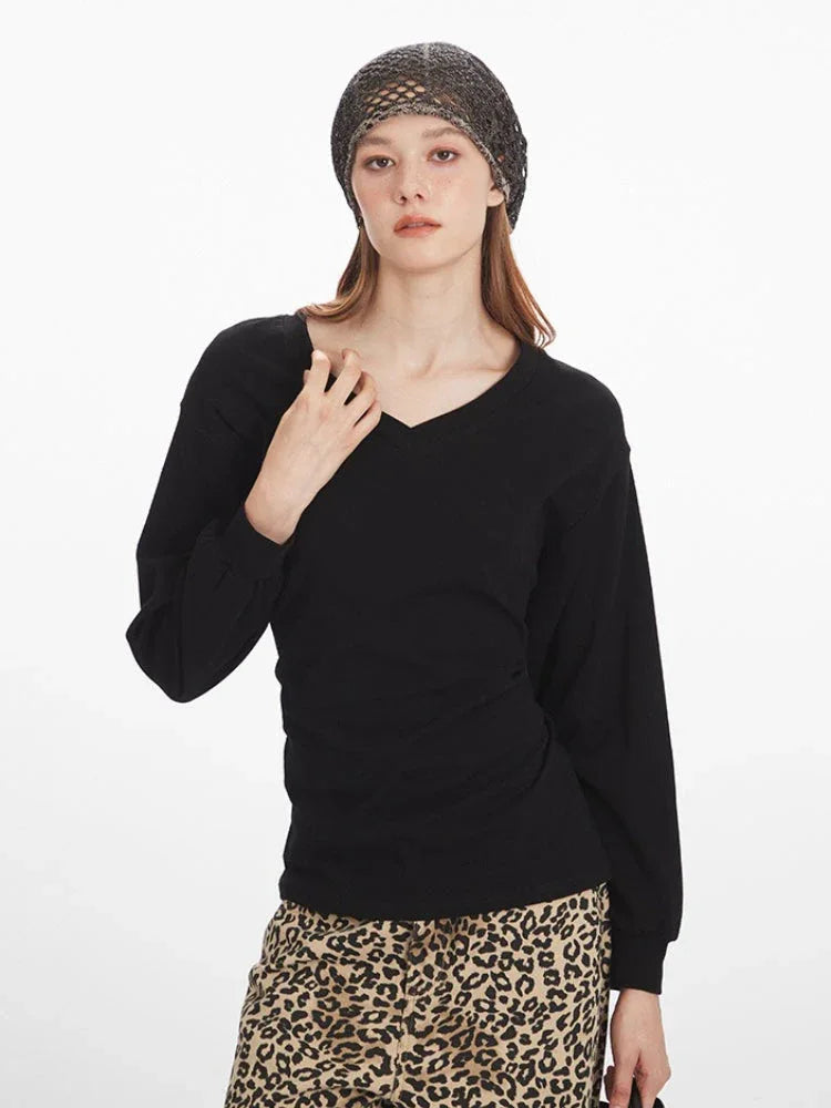 Close-up front view of a model wearing a black V-neck long-sleeve top and leopard print wide-leg pants.