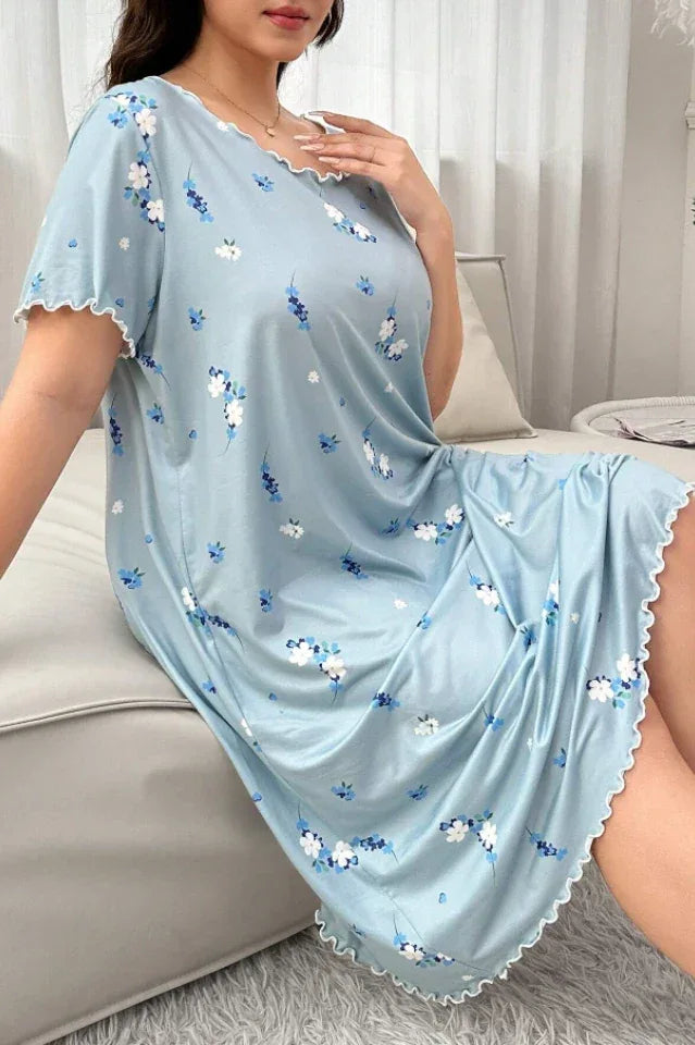 Close-up of a woman wearing a light blue floral print nightgown while sitting on a sofa.