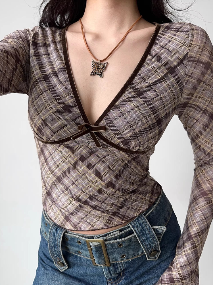 Side view of a model in a brown plaid long-sleeve top with velvet trim.