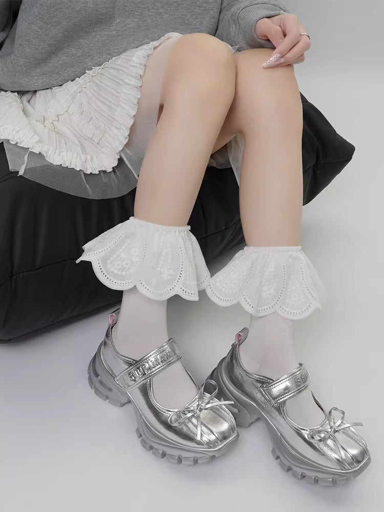 White lace ankle cuffs with eyelet detailing layered over white stockings.
