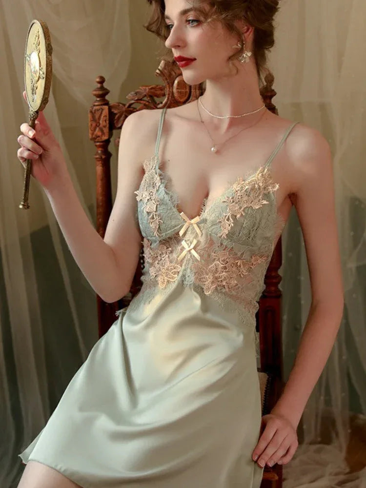 Woman wearing a light green satin slip dress with lace detailing and a matching robe. Main image
