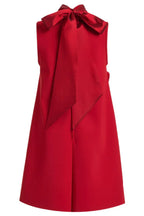 Close-up of the back of a red sleeveless A-line dress featuring a prominent satin bow at the neckline.