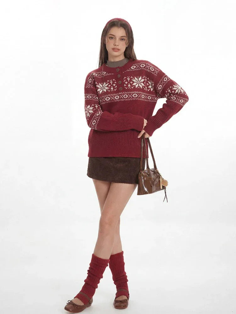 Woman wearing a red knit sweater with a white Fair Isle pattern and a button placket, posing with a handbag.