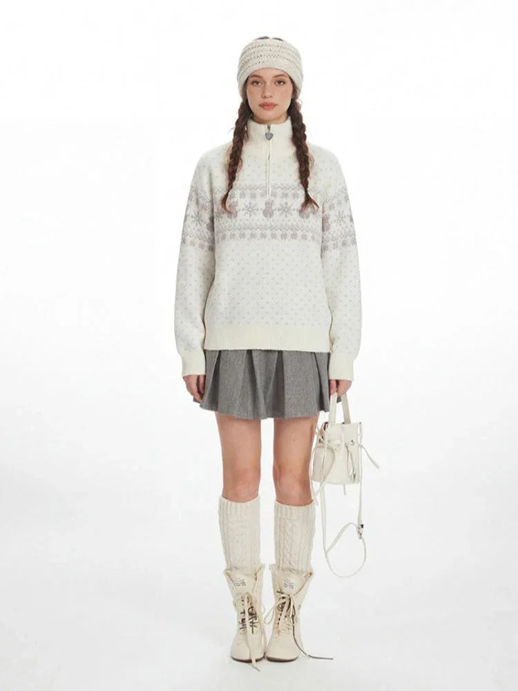 Woman wearing a white Fair Isle half zip knit sweater with a snowflake pattern and a heart zipper pull.