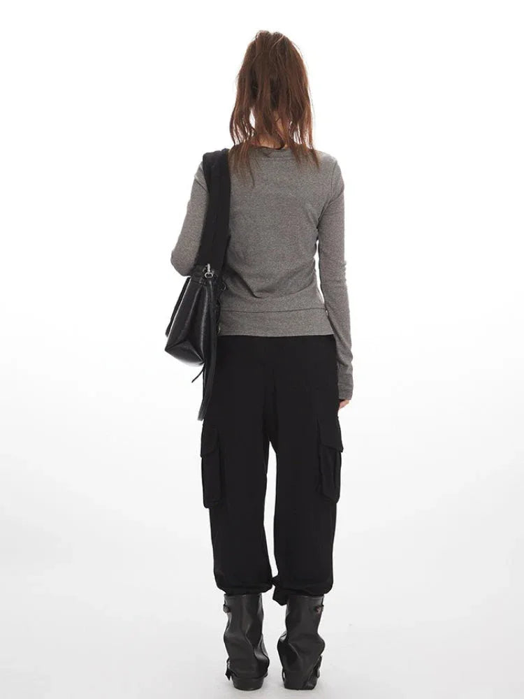 Model wearing a grey faux layered long sleeve henley top with black cargo pants