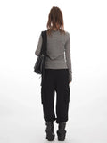 Back view of a woman in a grey faux layered henley top