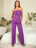 Woman posing with hands in pockets of purple wide-leg pants