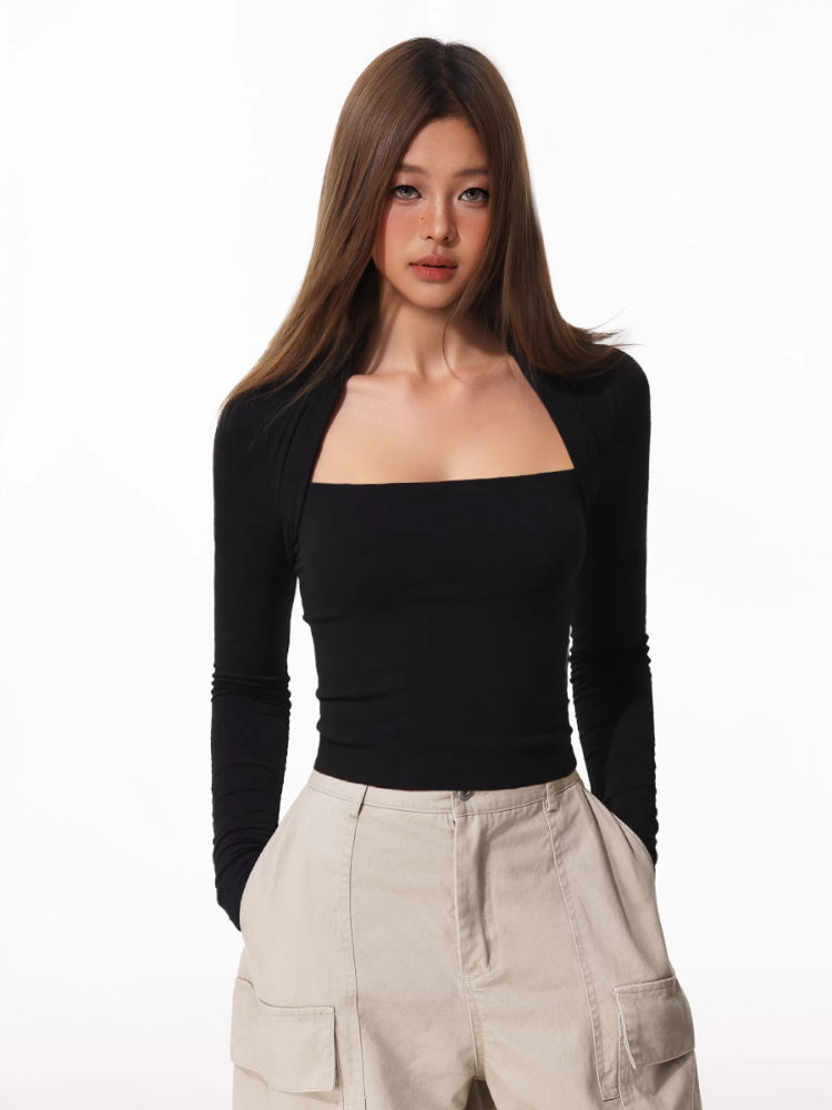 Woman wearing a black long-sleeve square neck top with a draped overlay, paired with beige cargo pants.